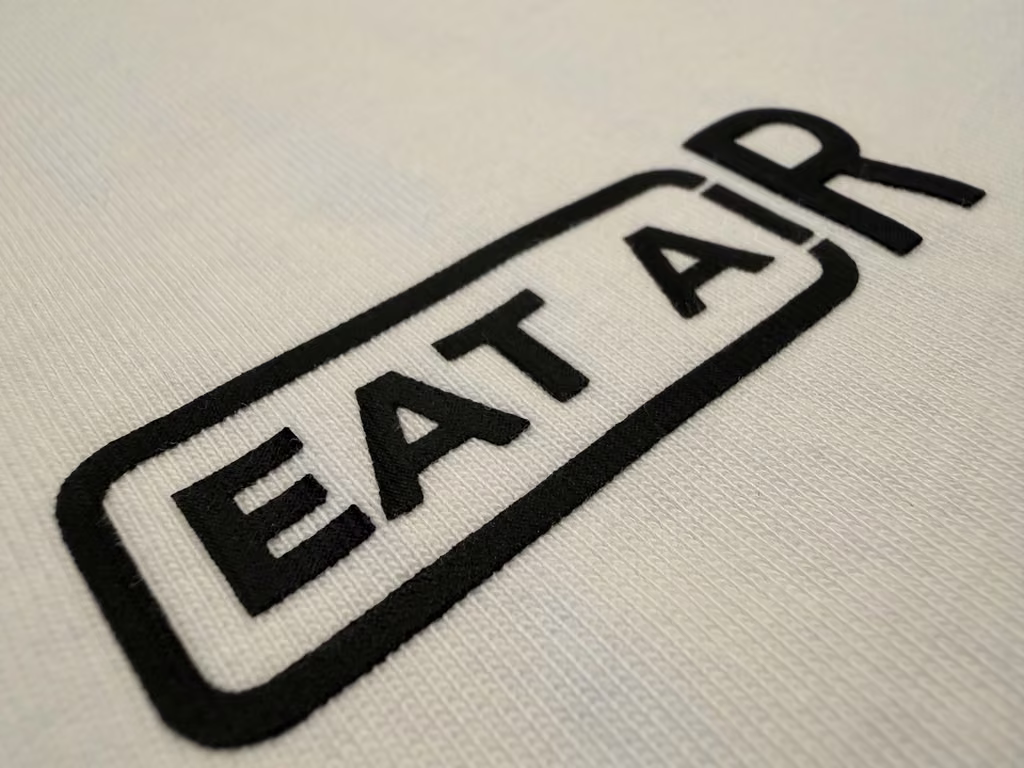 Close view of the EAT AIR chest mark and heavyweight cotton texture